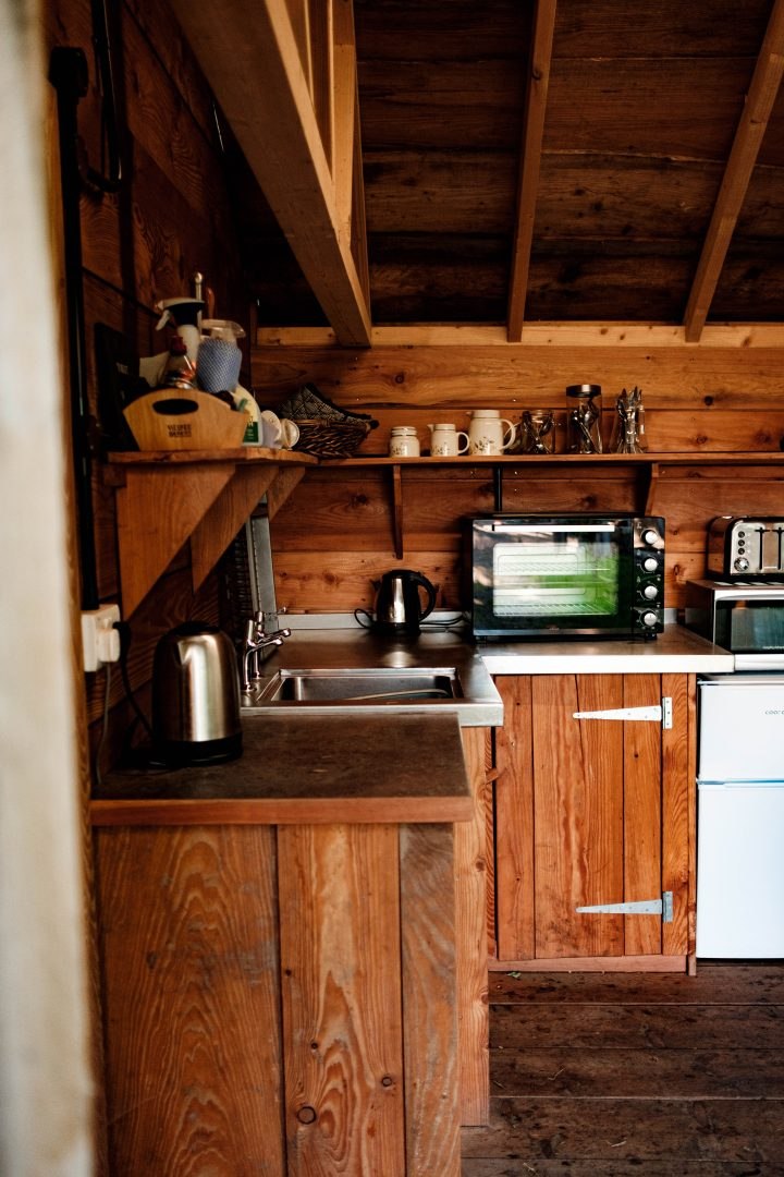 Inside the shared cabin kitchen, showing the sink, worktop, kettle and countertop oven
