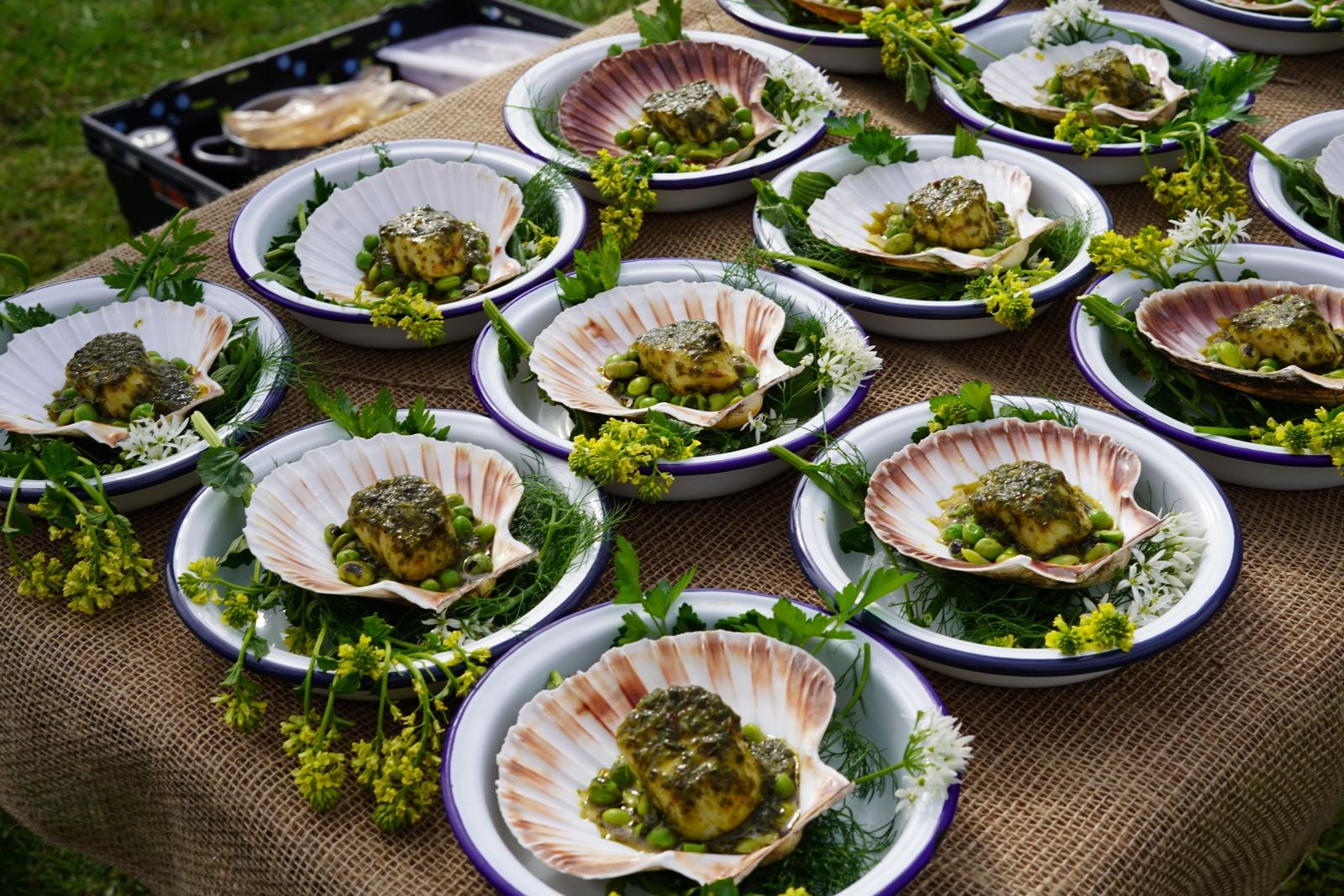 Celebration dishes served in scallop shells with greens and edible flowers