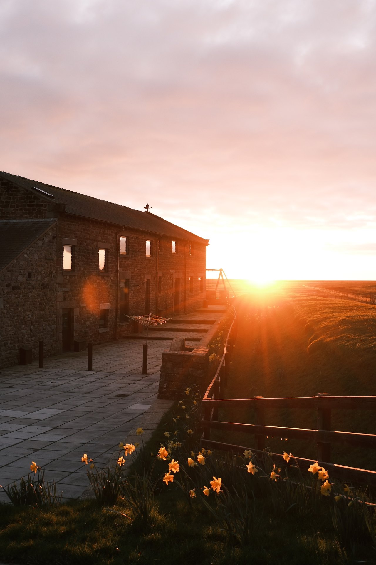 Golden sunset beside the stone holiday cottages at Patty’s Barn