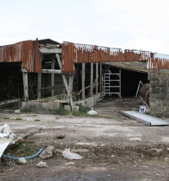 Farm outbuilding with timber supports, corrugated cladding and scaffolding during building work