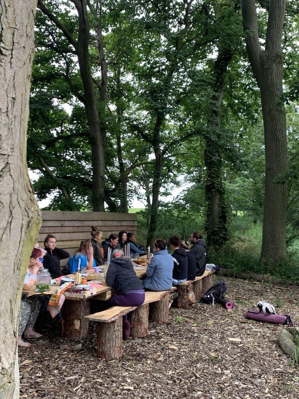 People gathered around a woodland table at Patty’s Barn